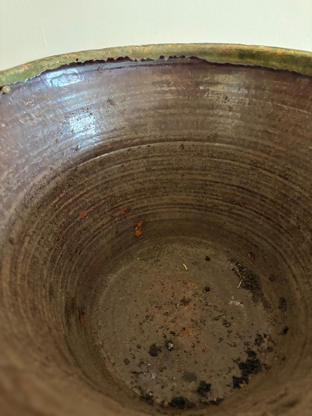 A large 19th-century circular terracotta dairy bowl featuring a dark glazed interior and weathered, unglazed exterior surface. View VII