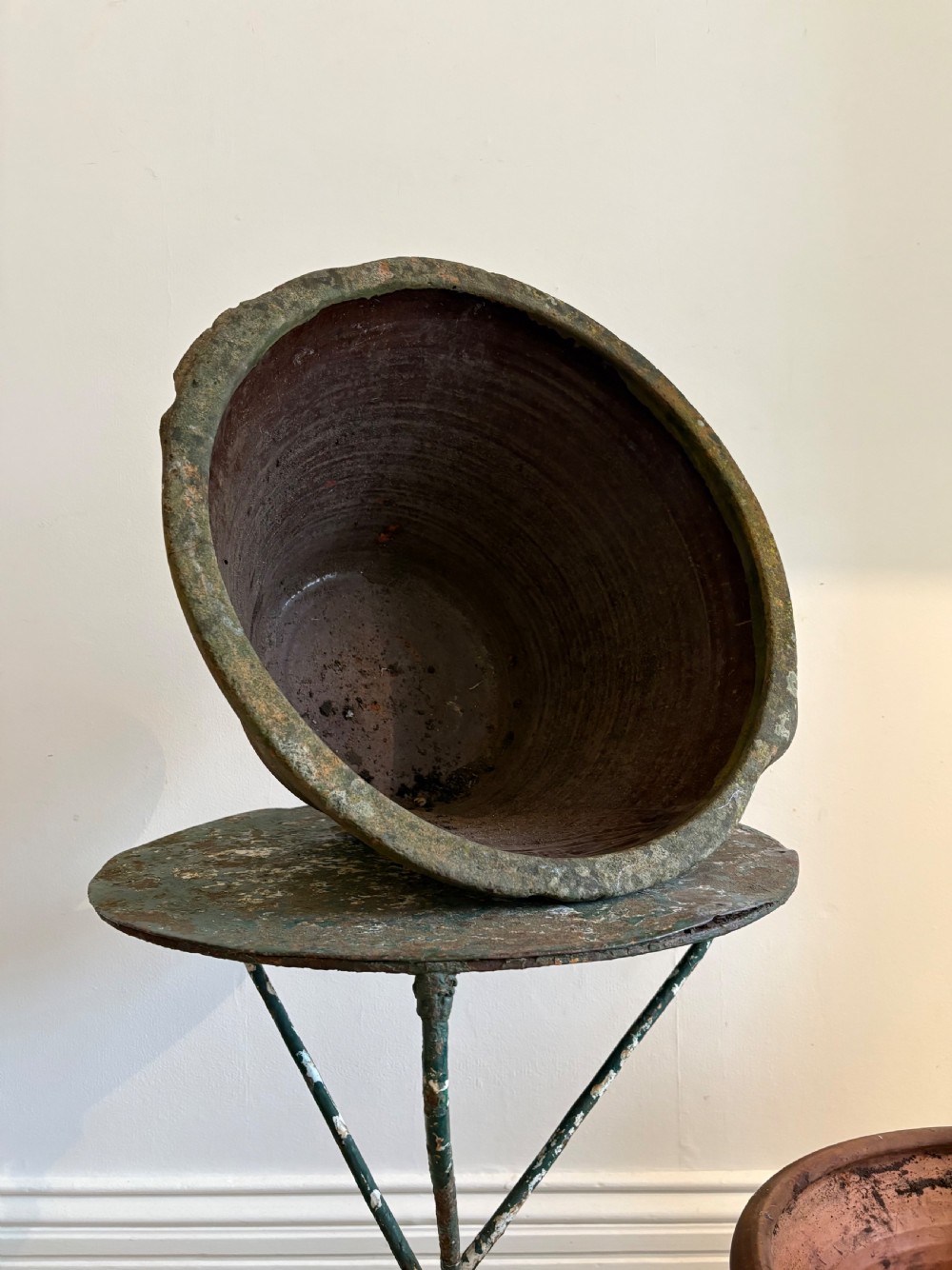 A large 19th-century circular terracotta dairy bowl featuring a dark glazed interior and weathered, unglazed exterior surface.