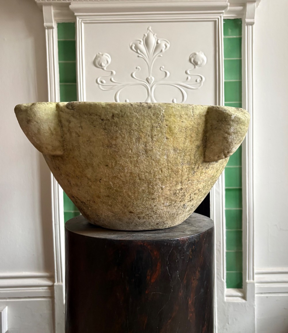 A large 18th-century carved white marble mortar featuring four thick corner lugs and a weathered, textured outer surface. View III