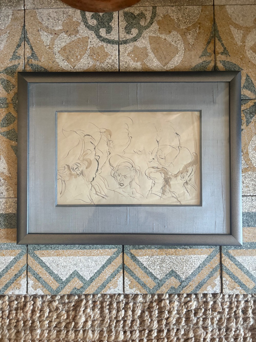 A framed 19th-century sepia pen and ink preparatory drawing depicting expressively sketched head studies on aged paper.