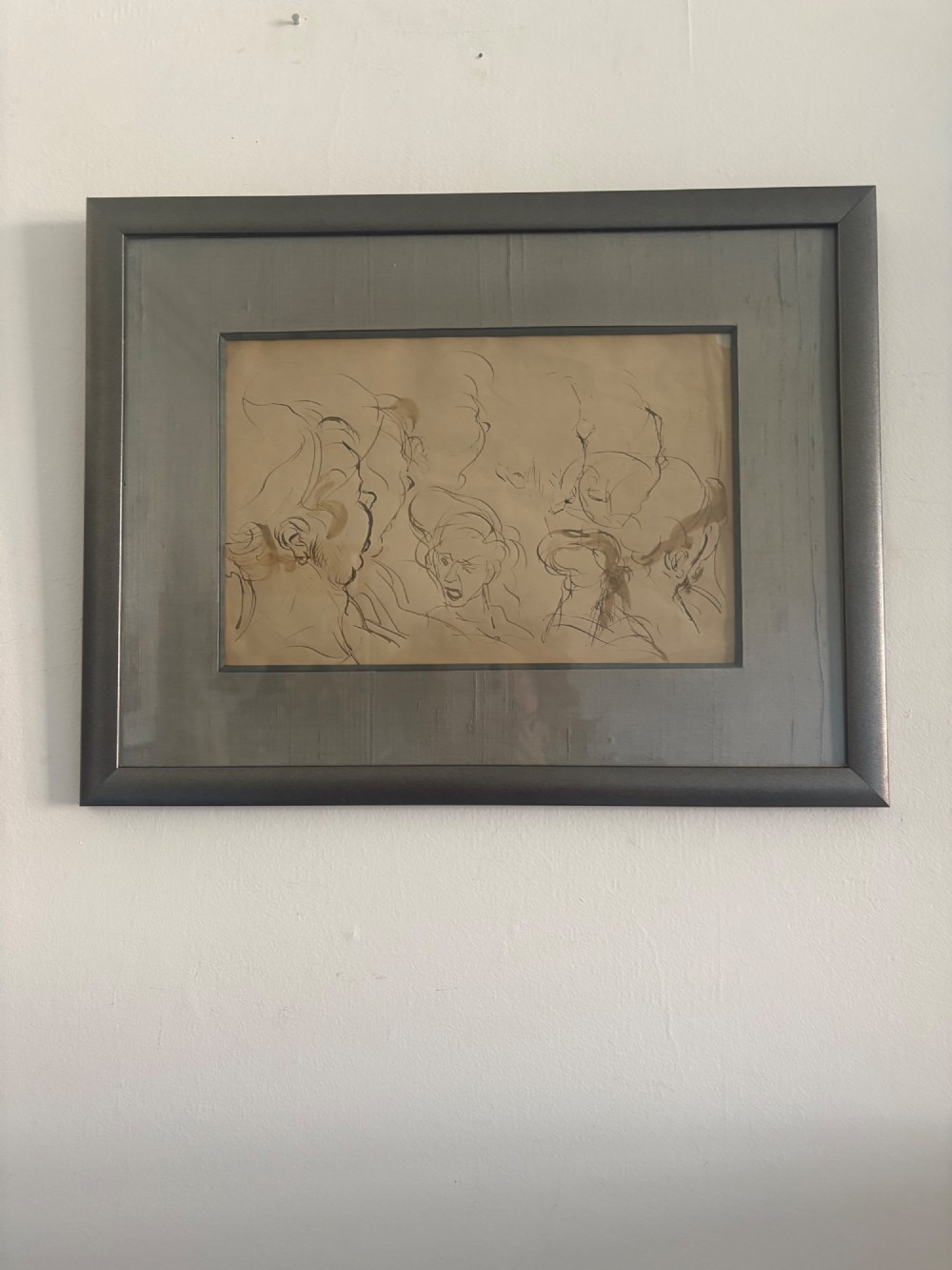 A framed 19th-century sepia pen and ink preparatory drawing depicting expressively sketched head studies on aged paper. View II