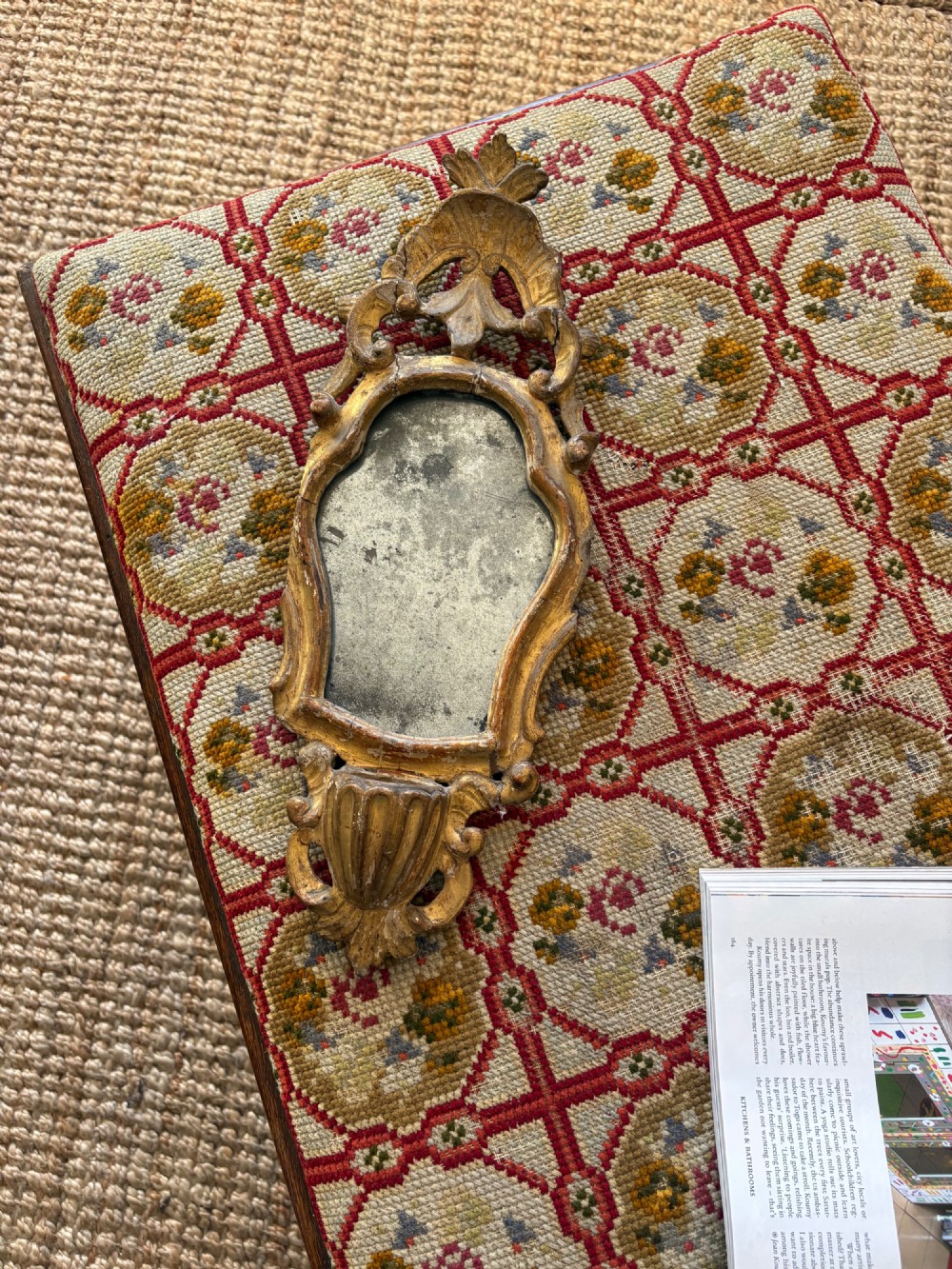 An 18th-century Italian Rococo carved giltwood cartouche wall mirror featuring ornate scrollwork, an upper crest, and a heavily foxed mirror glass plate. View XI