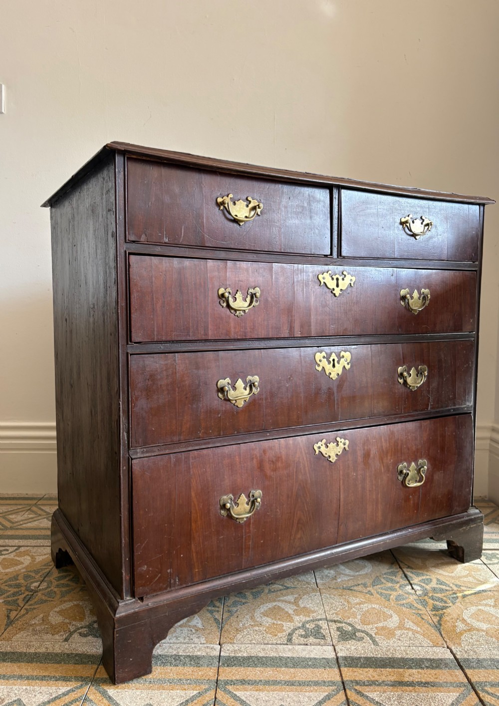A mid-18th-century Georgian walnut chest of drawers featuring a two-over-three drawer layout, brass handles with backplates, and bracket feet. View IV