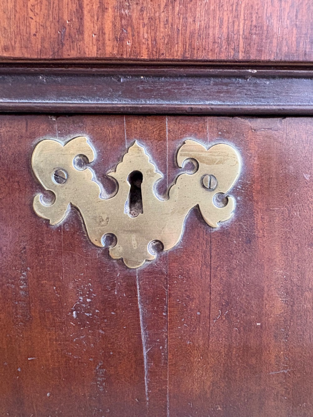A mid-18th-century Georgian walnut chest of drawers featuring a two-over-three drawer layout, brass handles with backplates, and bracket feet. View IX