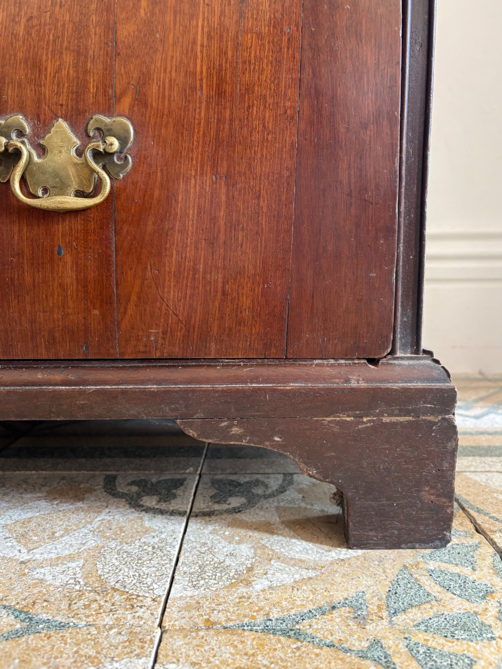 A mid-18th-century Georgian walnut chest of drawers featuring a two-over-three drawer layout, brass handles with backplates, and bracket feet. View X