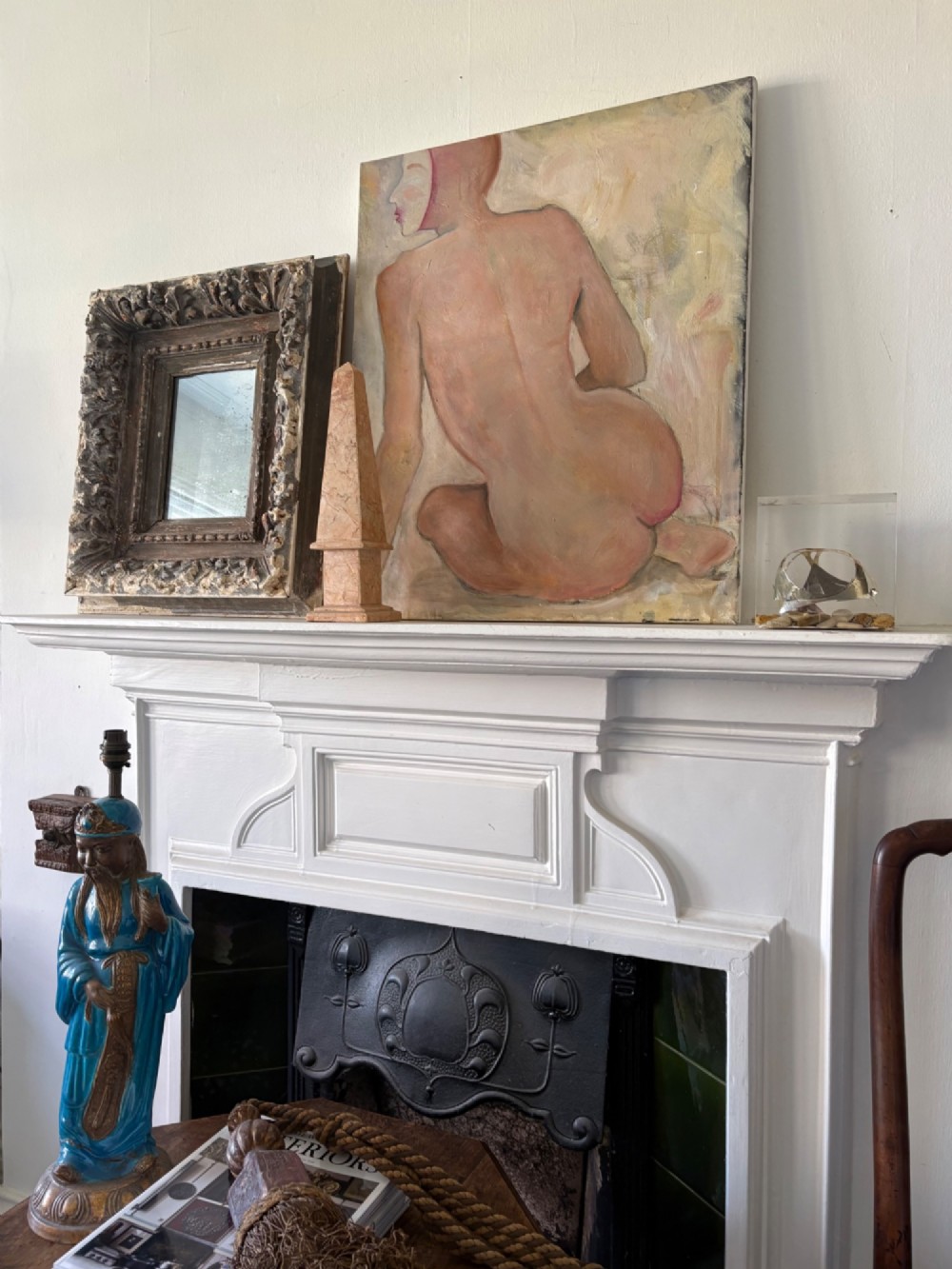 A small rectangular dark wood frame with heavily textured gesso carving enclosing a foxed mirror plate. View V