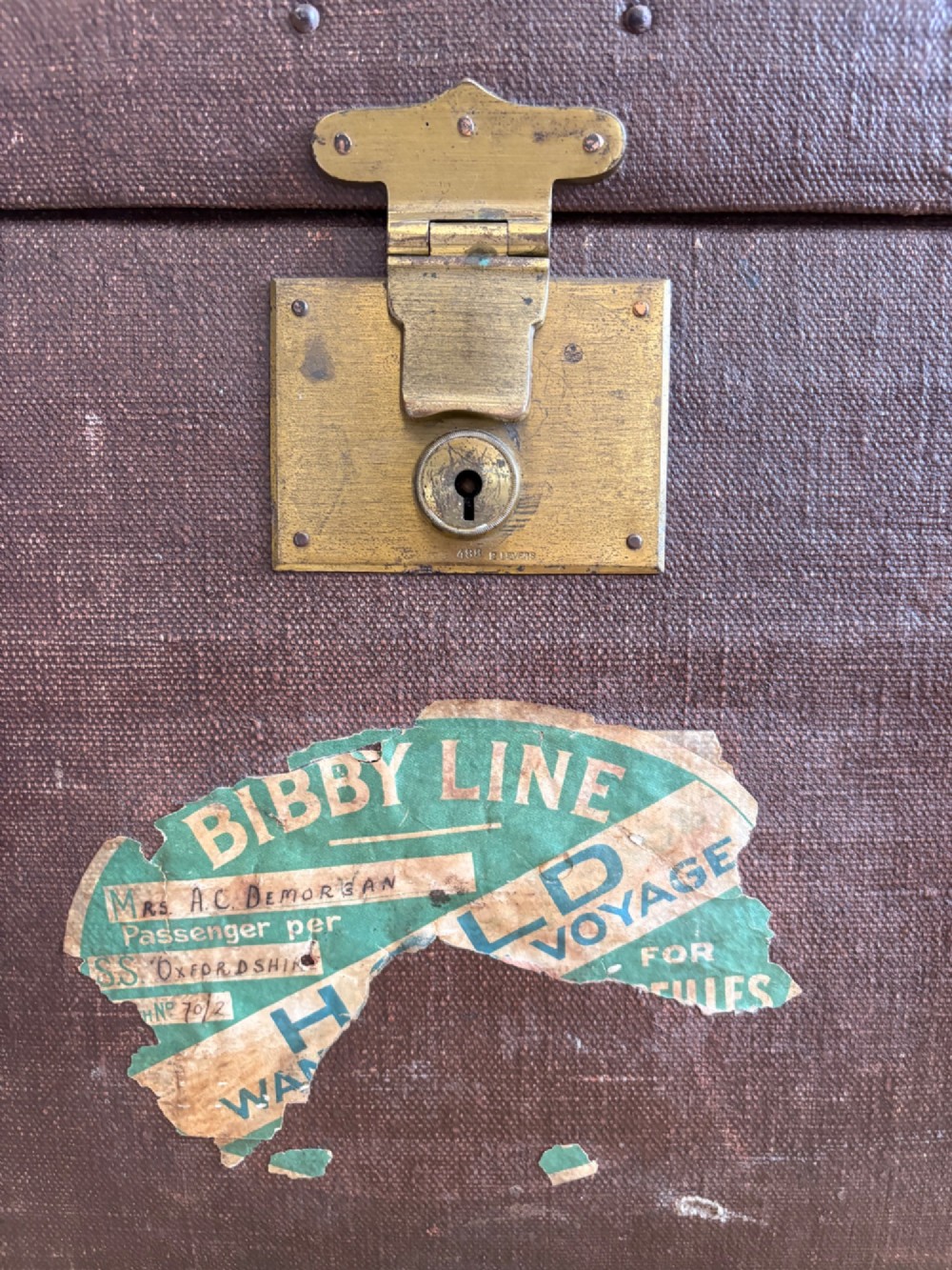 An Edwardian brown canvas and leather hat box trunk featuring brass latches, stitched leather trim, and an ocean liner travel label on the front. View IV