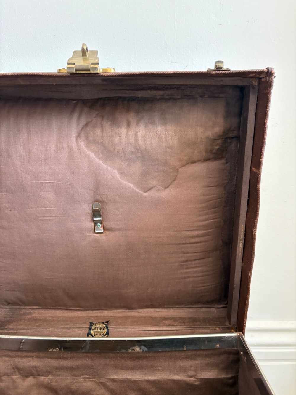 An Edwardian brown canvas and leather hat box trunk featuring brass latches, stitched leather trim, and an ocean liner travel label on the front. View IX