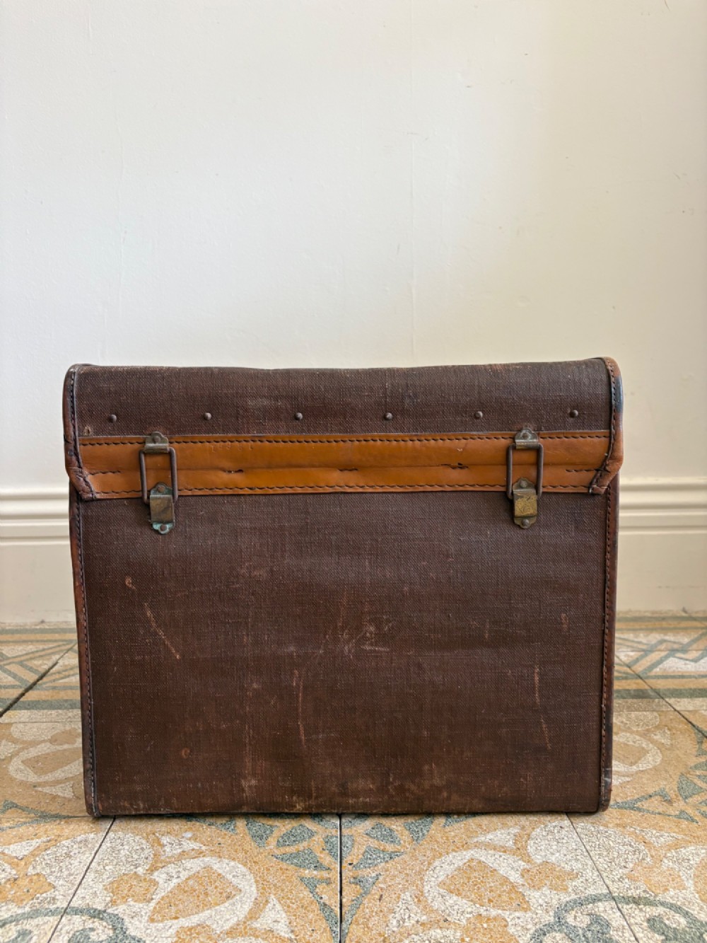 An Edwardian brown canvas and leather hat box trunk featuring brass latches, stitched leather trim, and an ocean liner travel label on the front. View XI