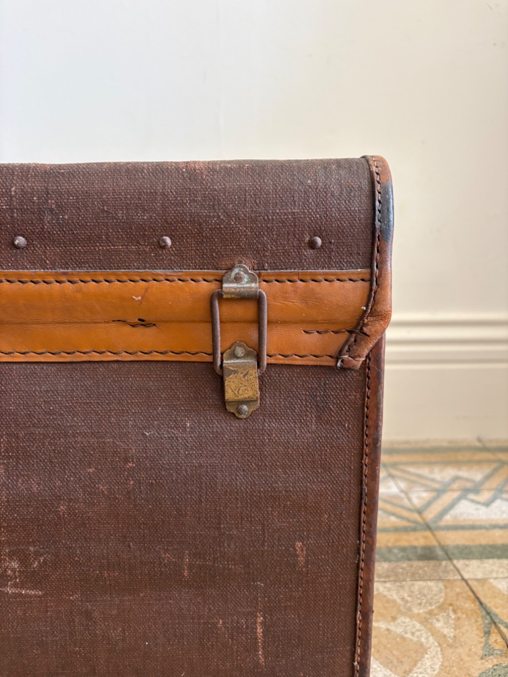 An Edwardian brown canvas and leather hat box trunk featuring brass latches, stitched leather trim, and an ocean liner travel label on the front. View XV