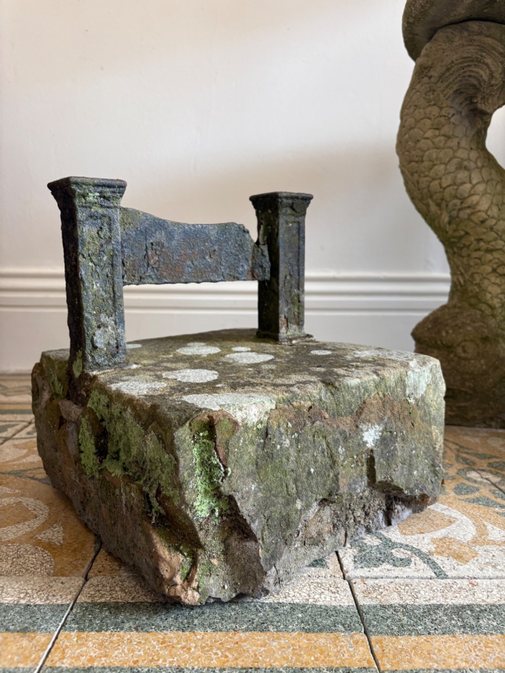 A 19th-century cast iron boot scraper with a central scraping blade set between two vertical pillars, mounted into a heavy hand-hewn stone block. View IV
