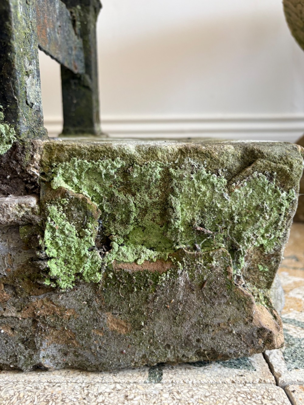 A 19th-century cast iron boot scraper with a central scraping blade set between two vertical pillars, mounted into a heavy hand-hewn stone block. View VI