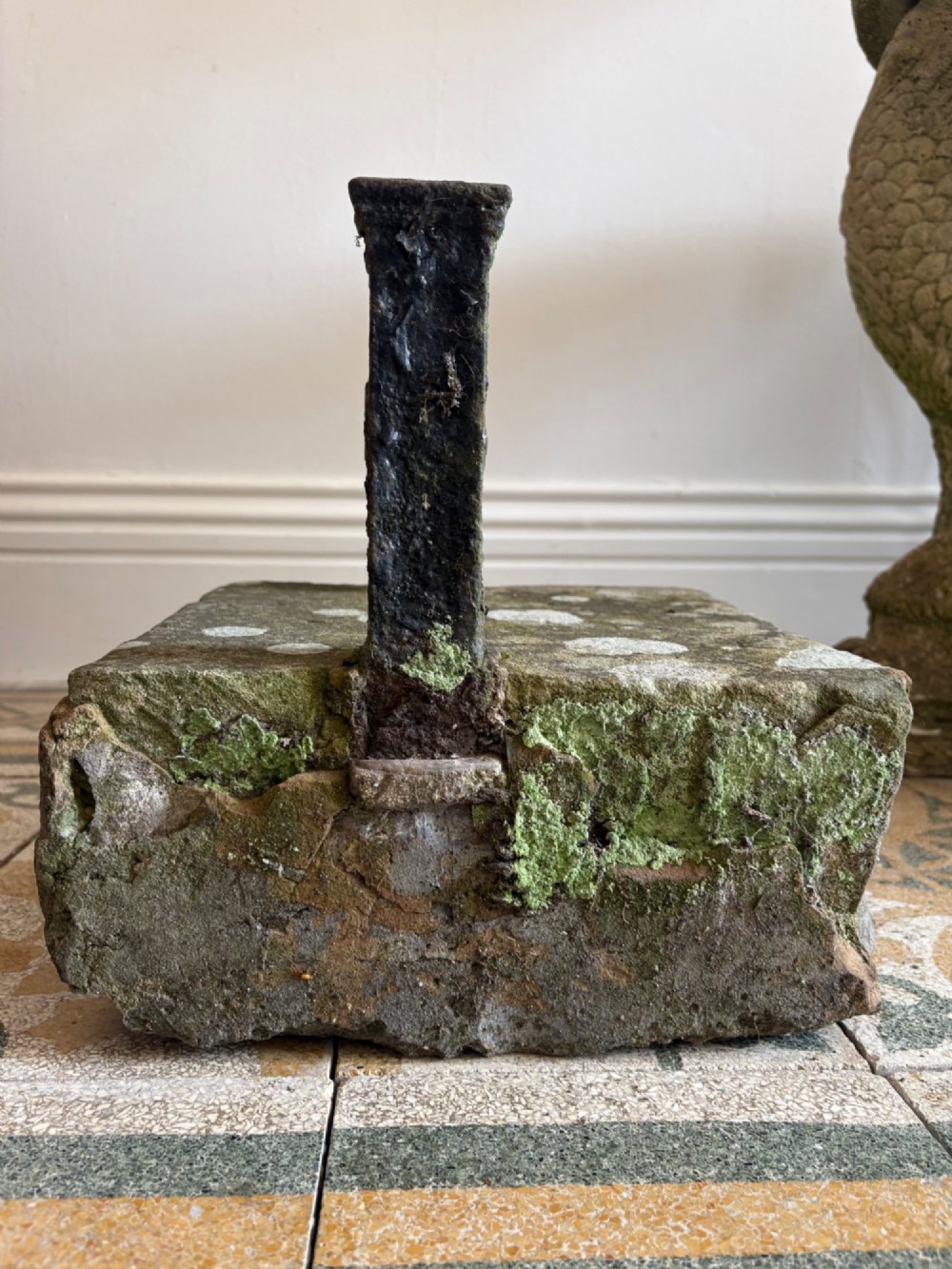 A 19th-century cast iron boot scraper with a central scraping blade set between two vertical pillars, mounted into a heavy hand-hewn stone block. View VII