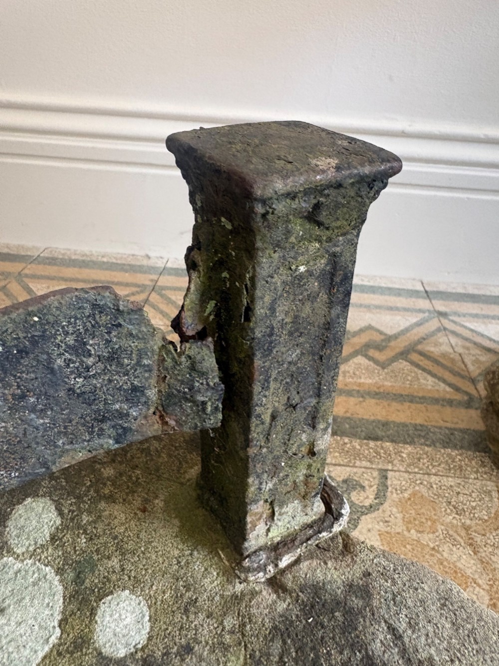 A 19th-century cast iron boot scraper with a central scraping blade set between two vertical pillars, mounted into a heavy hand-hewn stone block. View VIII