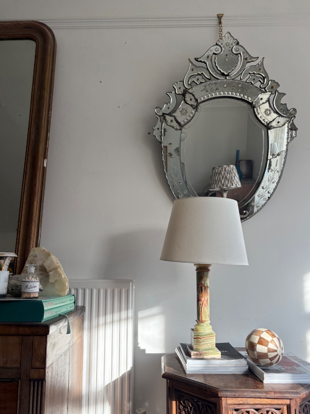An oval Venetian wall mirror featuring an etched glass frame with floral motifs, a scrollwork crest, and a bevelled centre mirror with light foxing. View XV