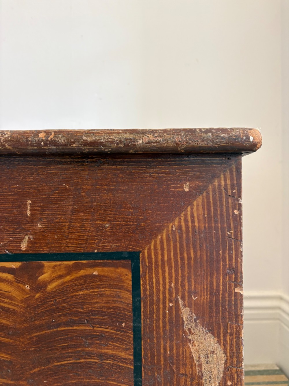 A 19th-century rectangular pine trunk featuring decorative scumble glazed painted panels, a hinged lid, and turned bun feet. View IV