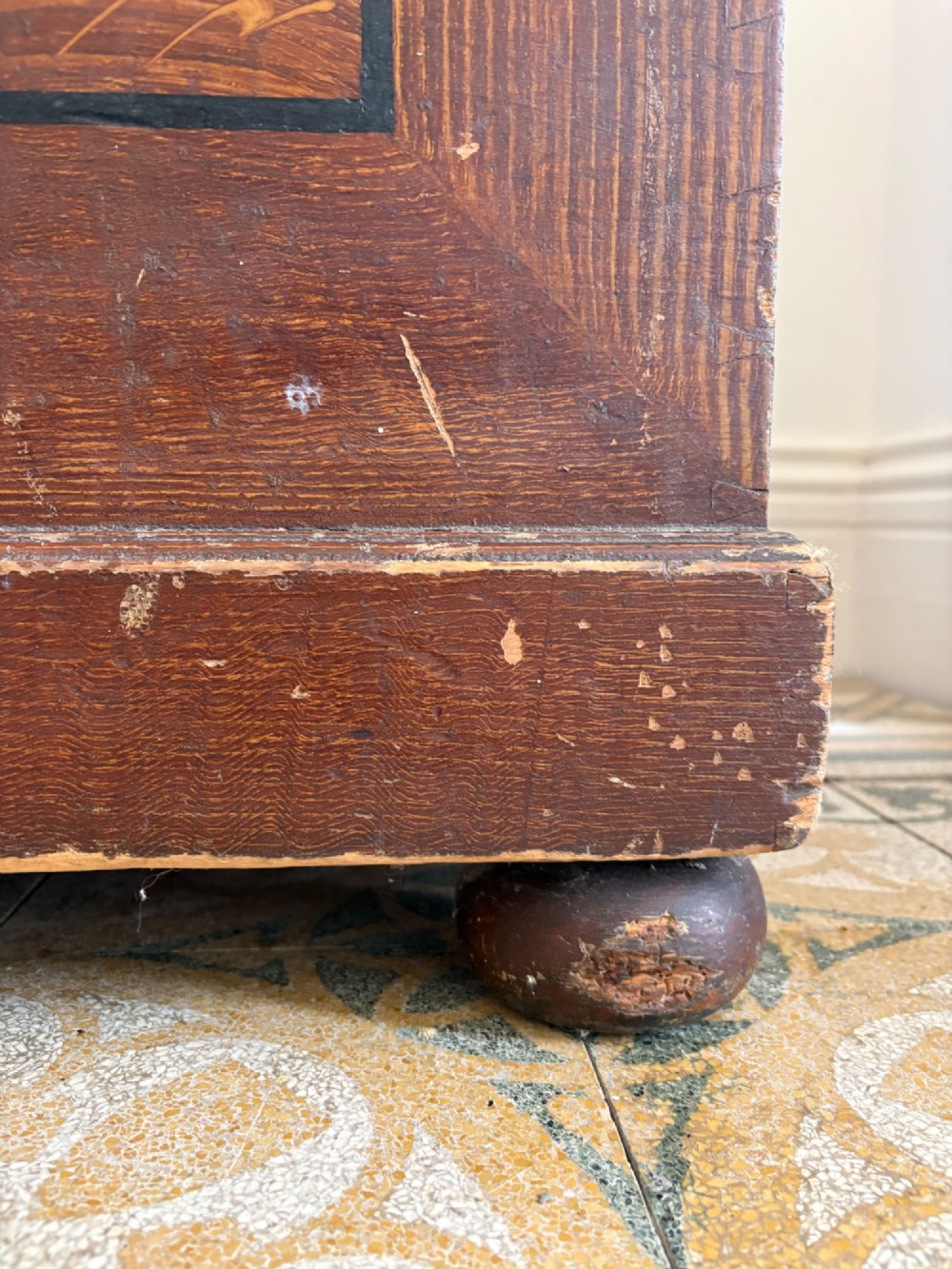 A 19th-century rectangular pine trunk featuring decorative scumble glazed painted panels, a hinged lid, and turned bun feet. View VI