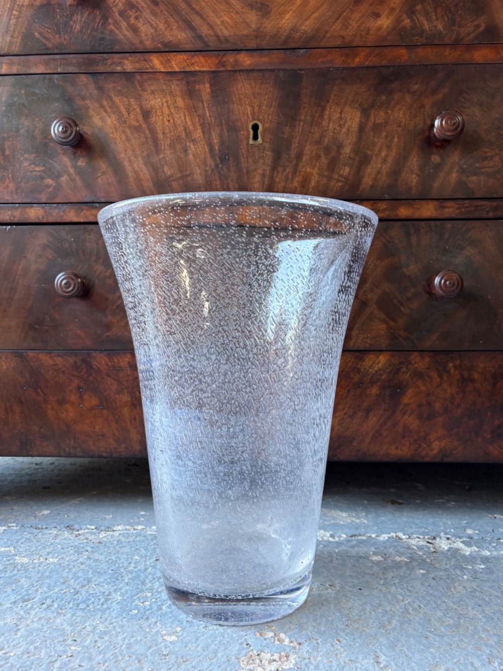 A tall flared Art Deco clear crystal vase featuring a densely bubble-textured interior.