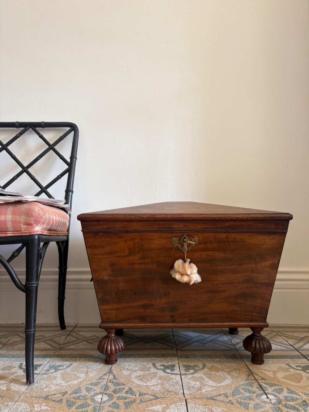 A Regency tapered mahogany sarcophagus cellarette featuring a hinged lid, keyhole with brass escutcheon, and turned gadrooned feet.