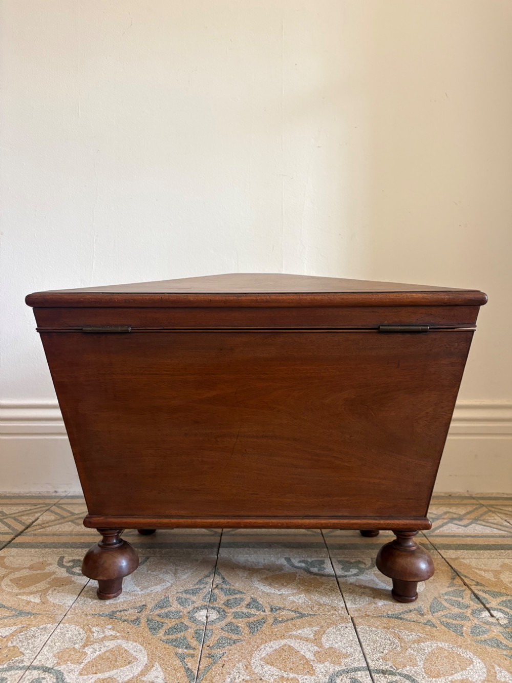 A Regency tapered mahogany sarcophagus cellarette featuring a hinged lid, keyhole with brass escutcheon, and turned gadrooned feet. View XIV