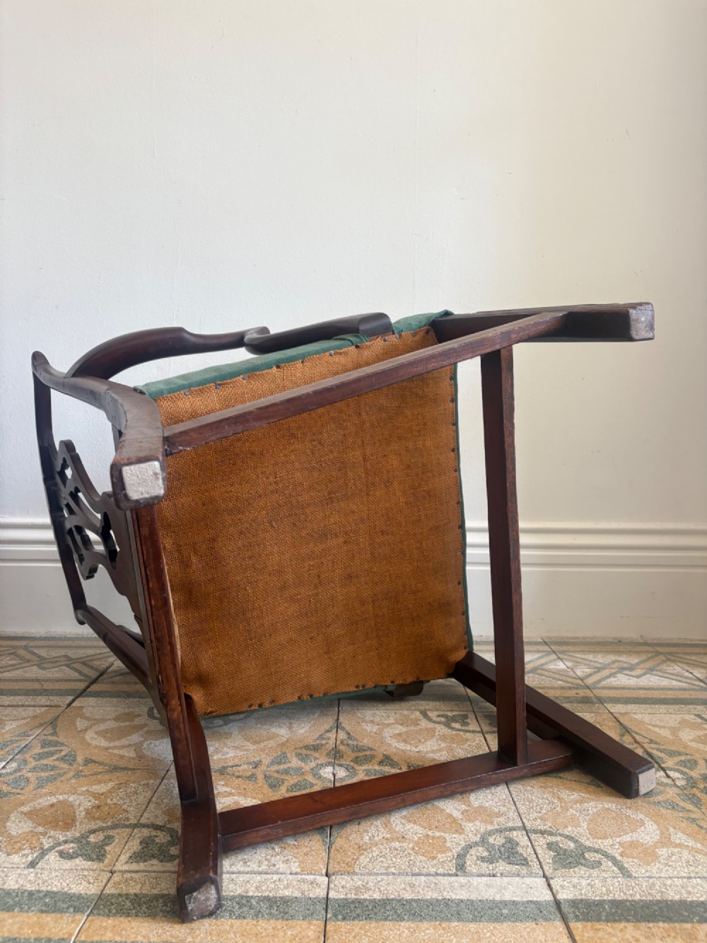 A George III mahogany elbow chair featuring a carved pierced splat back, swept armrests, and a green upholstered seat. View VIII