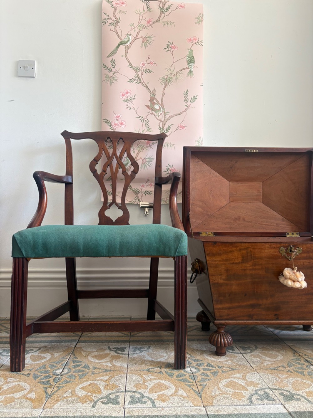 A George III mahogany elbow chair featuring a carved pierced splat back, swept armrests, and a green upholstered seat. View IX