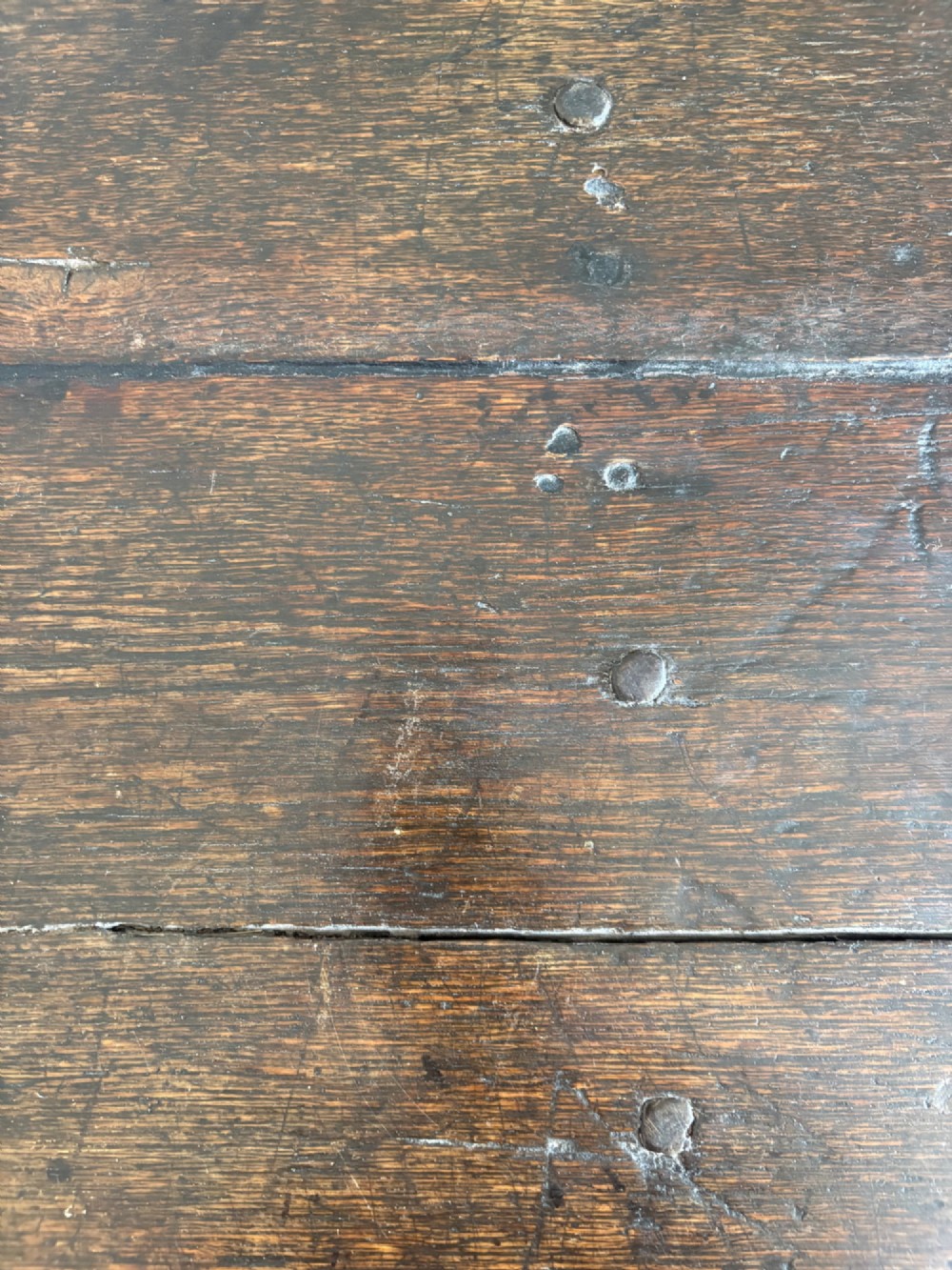 A dark oak gateleg table with a drop-leaf plank top and turned baluster legs joined by low stretchers. View V