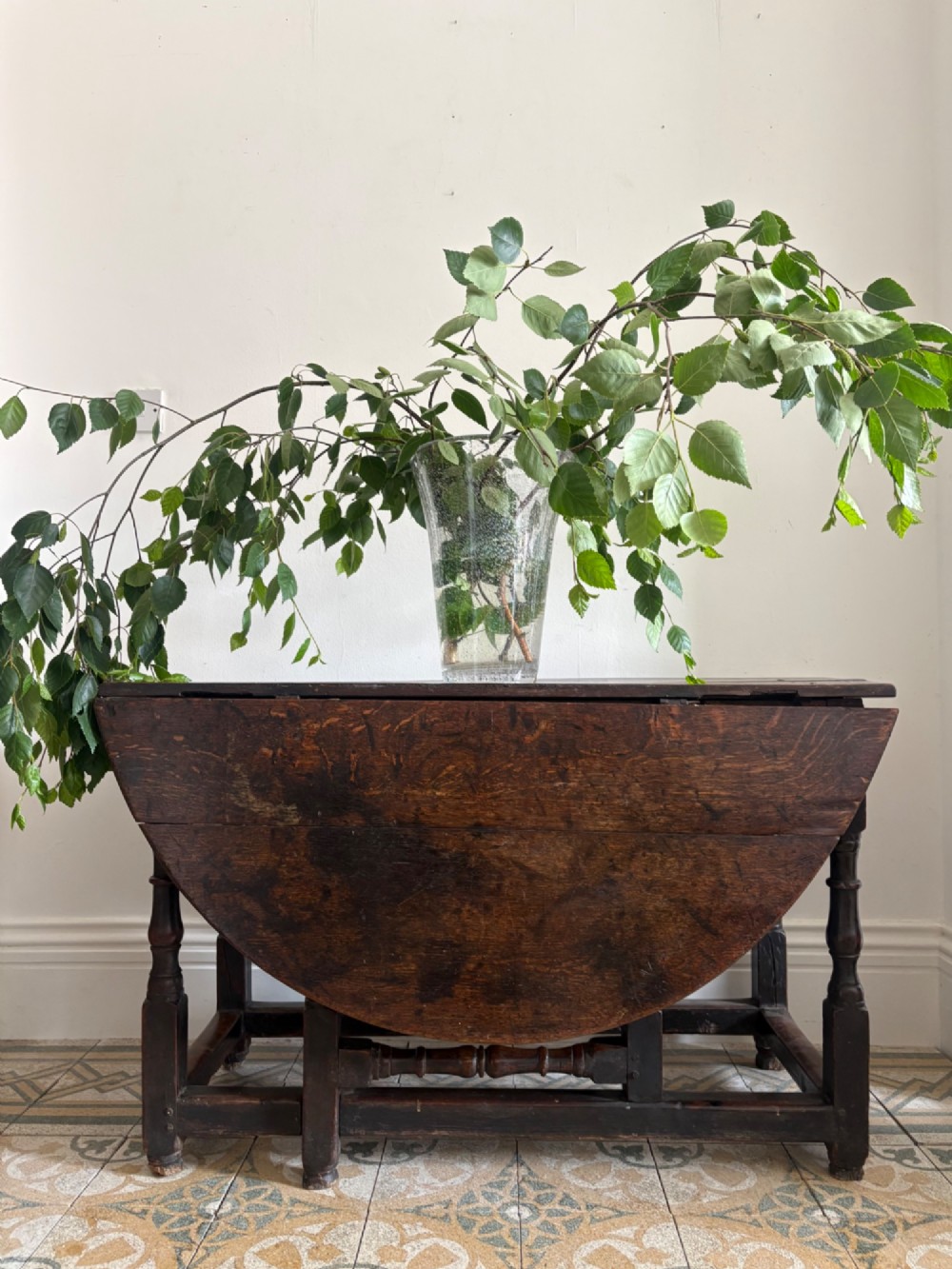 A dark oak gateleg table with a drop-leaf plank top and turned baluster legs joined by low stretchers. View VI