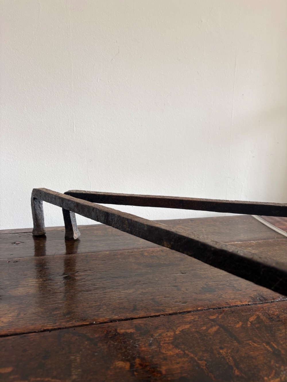 A pair of tall 19th-century black wrought iron fire dogs featuring hand-twisted shafts, scrollwork feet, and circular top ring terminals. View VIII
