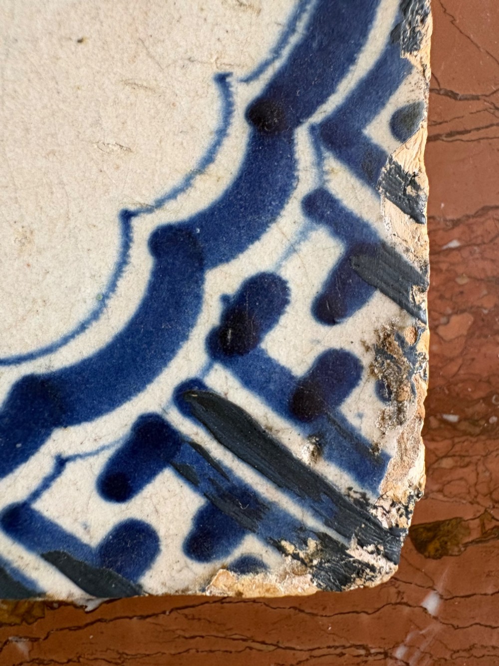A square 17th-century tin-glazed earthenware tile featuring a hand-painted cobalt blue swan motif inside a scalloped border with geometric corner details. View IV