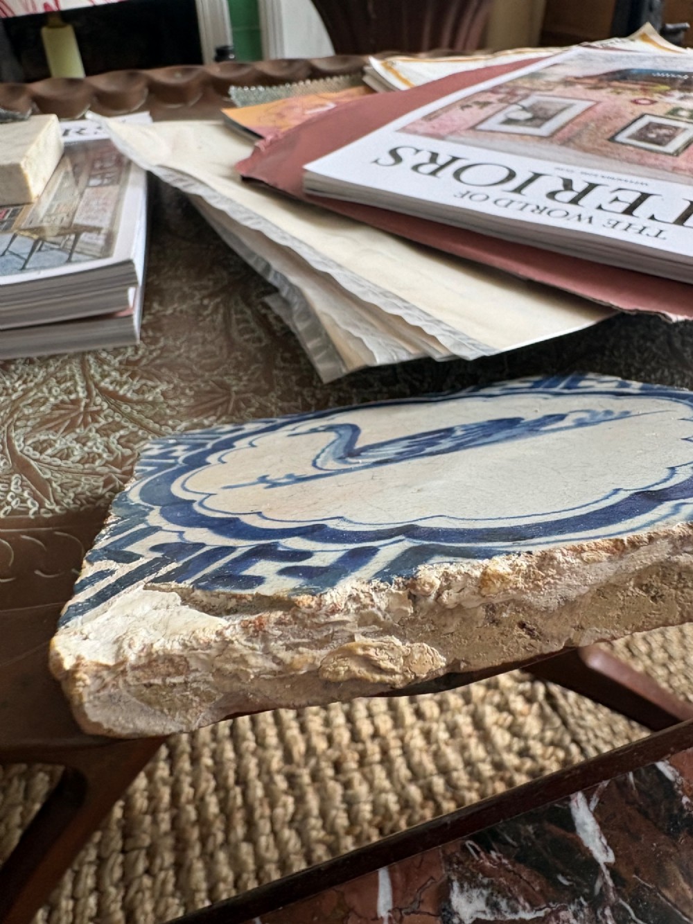 A square 17th-century tin-glazed earthenware tile featuring a hand-painted cobalt blue swan motif inside a scalloped border with geometric corner details. View X