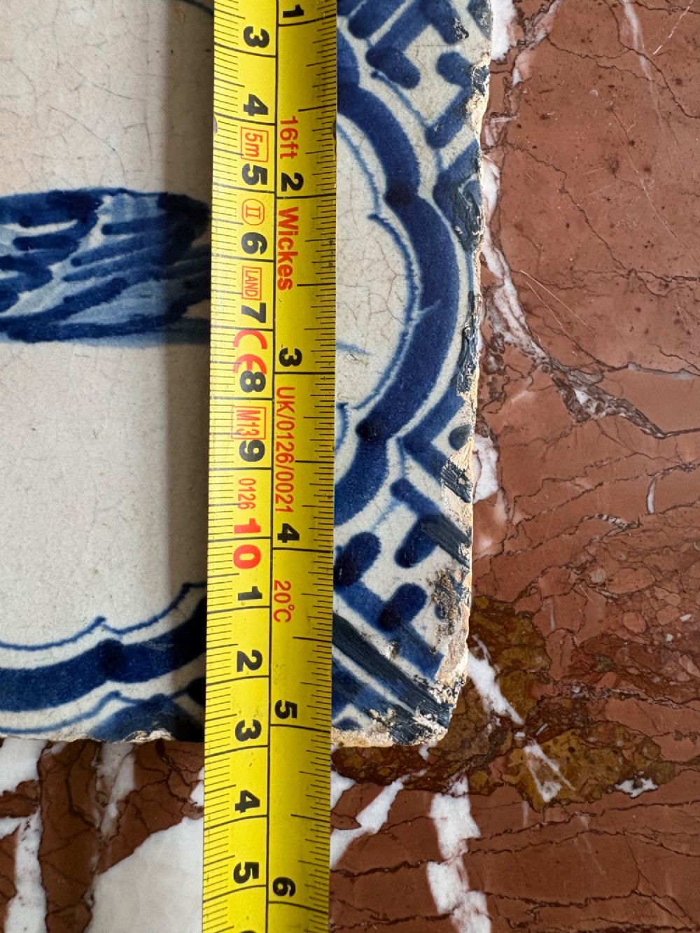 A square 17th-century tin-glazed earthenware tile featuring a hand-painted cobalt blue swan motif inside a scalloped border with geometric corner details. View XI