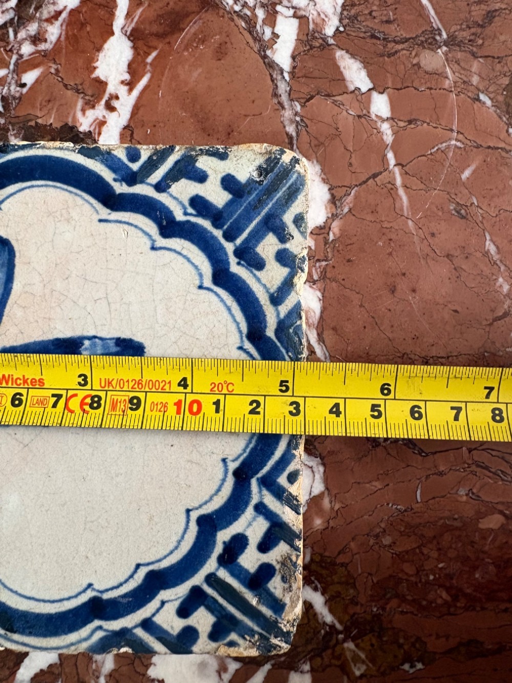 A square 17th-century tin-glazed earthenware tile featuring a hand-painted cobalt blue swan motif inside a scalloped border with geometric corner details. View XII