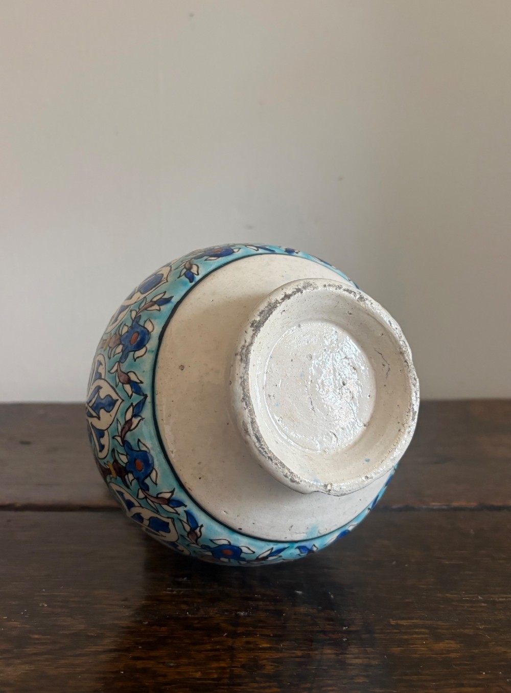 A hand-painted 19th-century Iznik style fritware bottle vase decorated with turquoise, cobalt blue, and red floral arabesque motifs. View IV