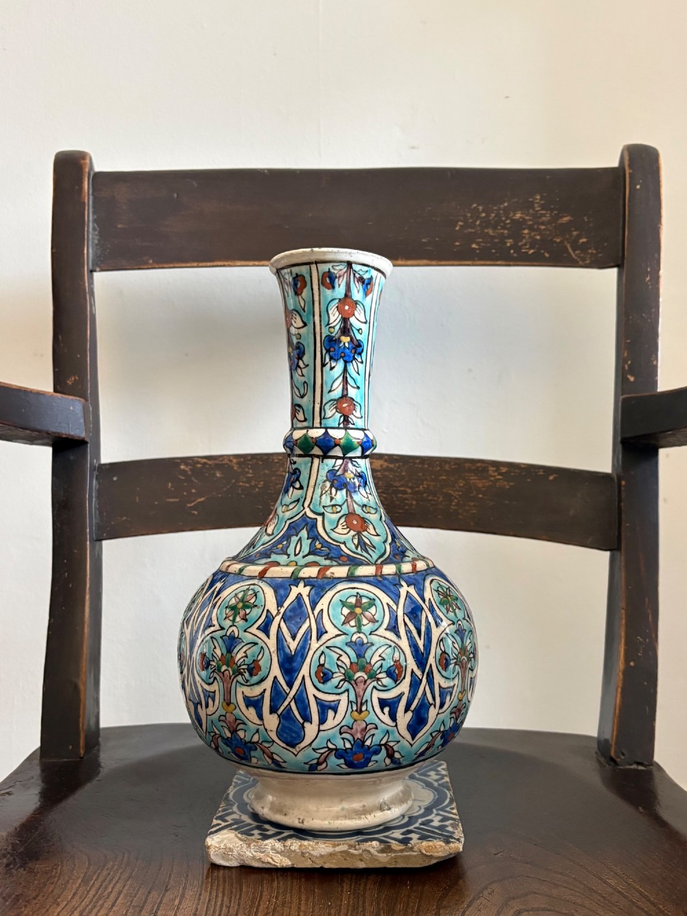 A hand-painted 19th-century Iznik style fritware bottle vase decorated with turquoise, cobalt blue, and red floral arabesque motifs. View VI