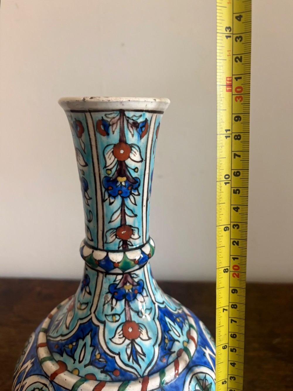 A hand-painted 19th-century Iznik style fritware bottle vase decorated with turquoise, cobalt blue, and red floral arabesque motifs. View IX