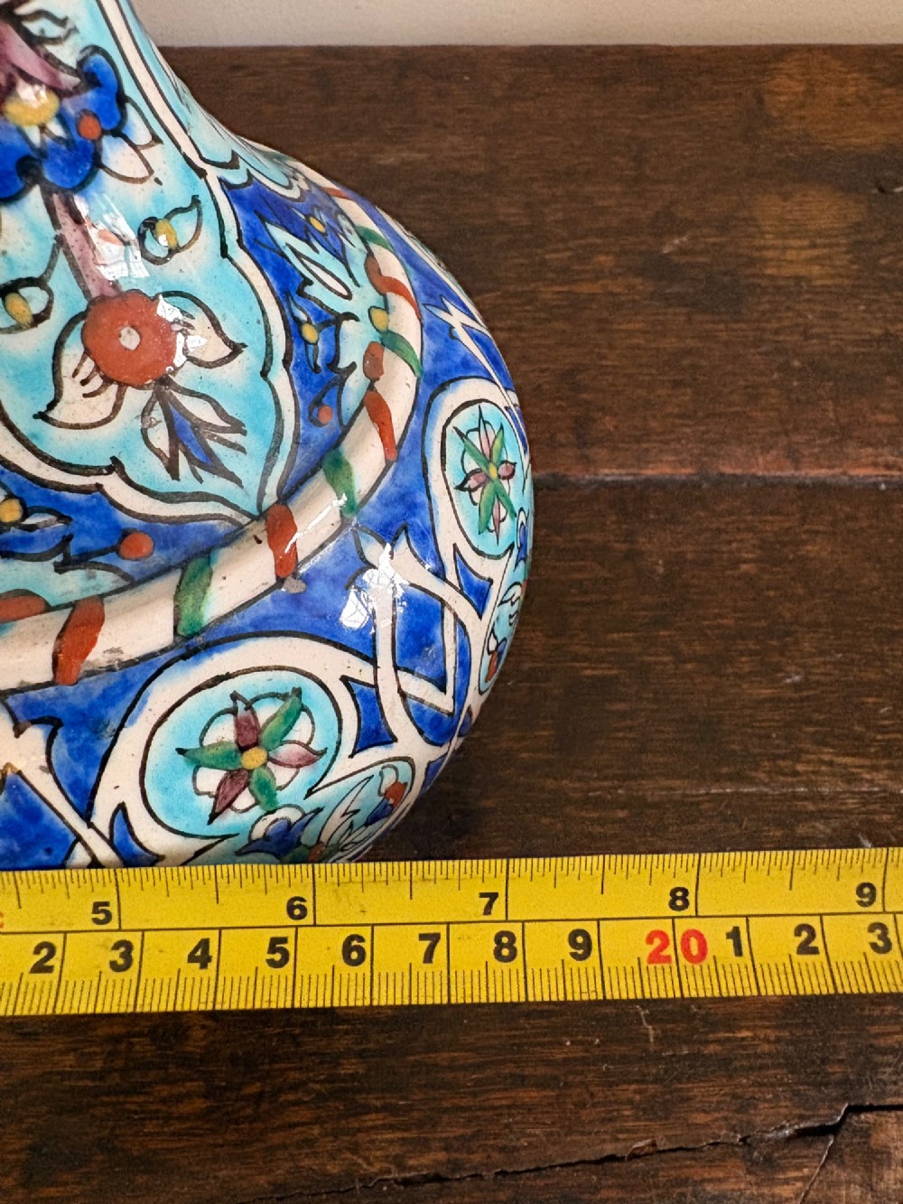 A hand-painted 19th-century Iznik style fritware bottle vase decorated with turquoise, cobalt blue, and red floral arabesque motifs. View XI