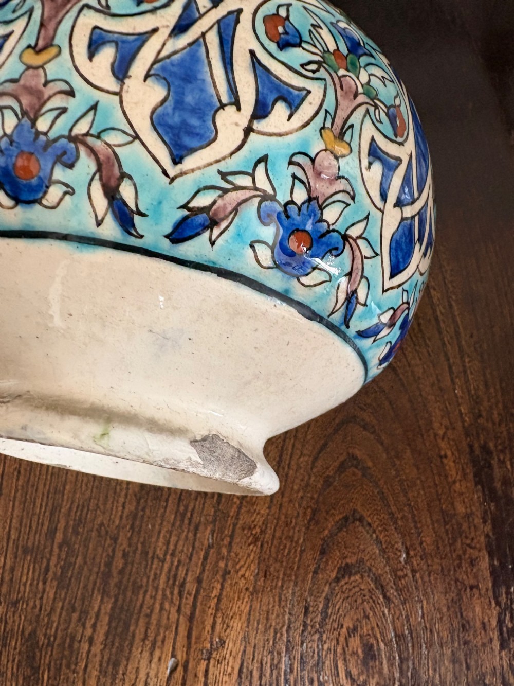 A hand-painted 19th-century Iznik style fritware bottle vase decorated with turquoise, cobalt blue, and red floral arabesque motifs. View XIII
