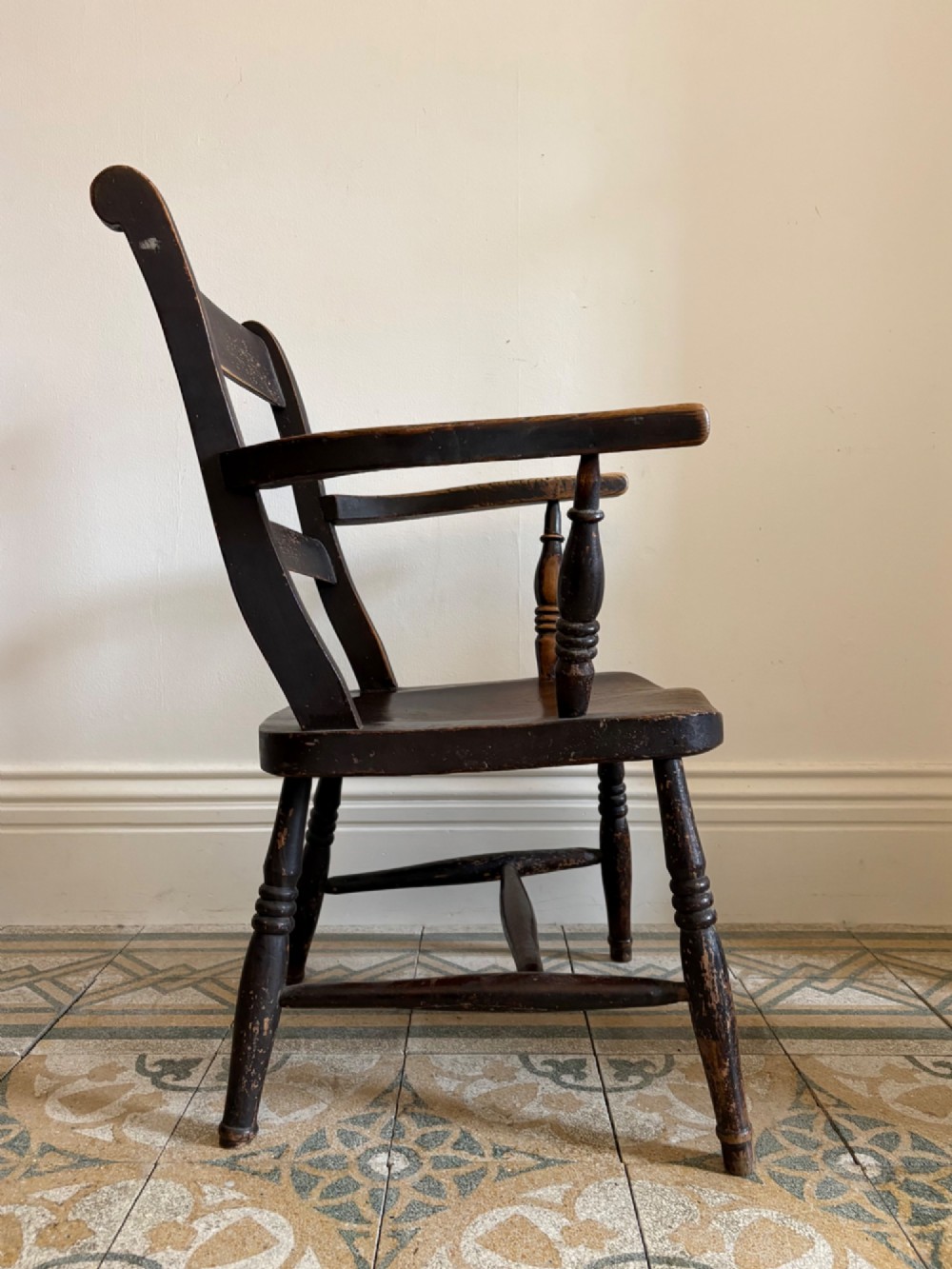 A mid-19th-century ebonised Thames Valley Windsor armchair with a slat back, shaped elm seat, and turned wooden legs. View II