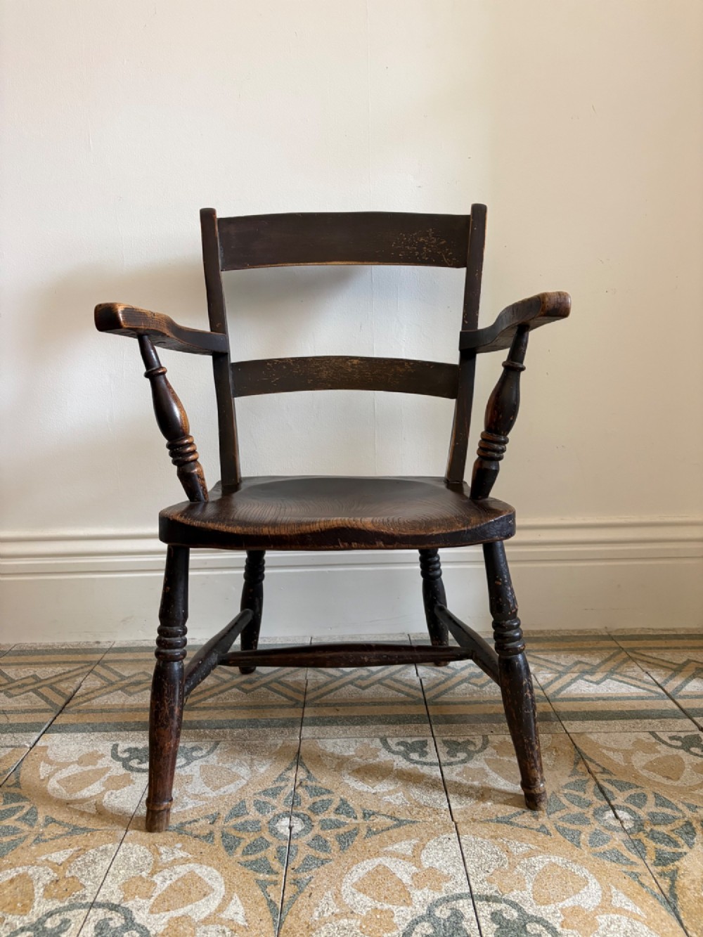 A mid-19th-century ebonised Thames Valley Windsor armchair with a slat back, shaped elm seat, and turned wooden legs. View IV