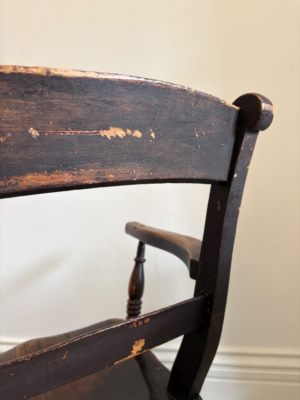 A mid-19th-century ebonised Thames Valley Windsor armchair with a slat back, shaped elm seat, and turned wooden legs. View VI