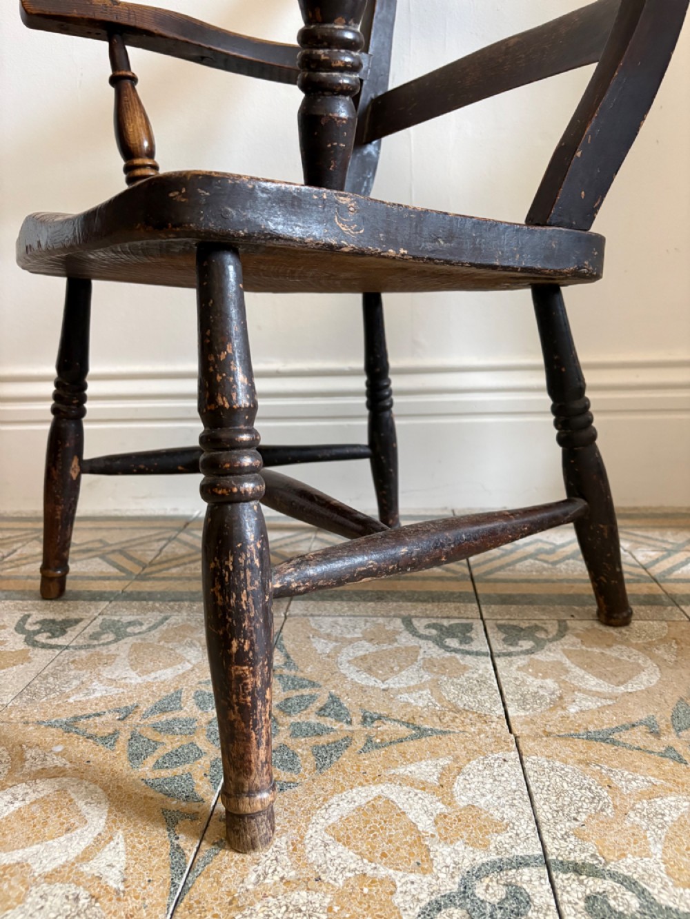 A mid-19th-century ebonised Thames Valley Windsor armchair with a slat back, shaped elm seat, and turned wooden legs. View IX