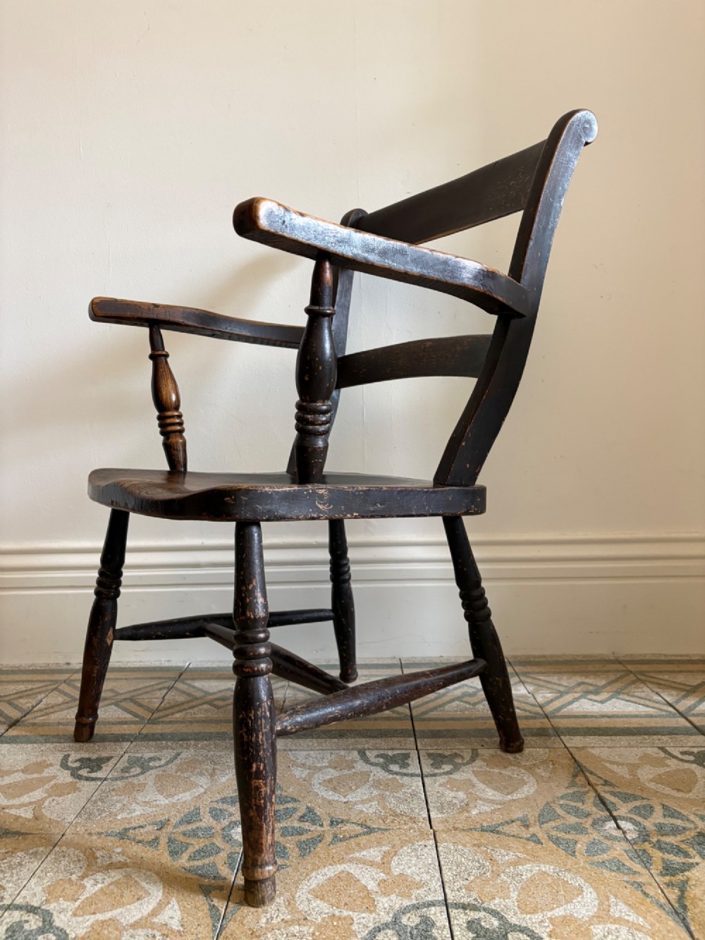 A mid-19th-century ebonised Thames Valley Windsor armchair with a slat back, shaped elm seat, and turned wooden legs. View X