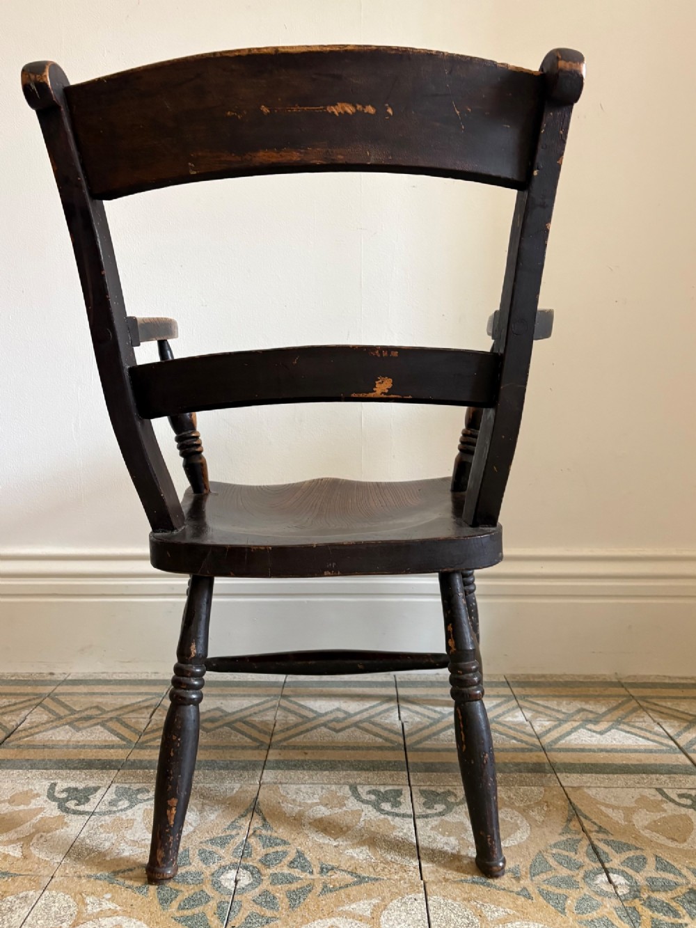 A mid-19th-century ebonised Thames Valley Windsor armchair with a slat back, shaped elm seat, and turned wooden legs. View XII