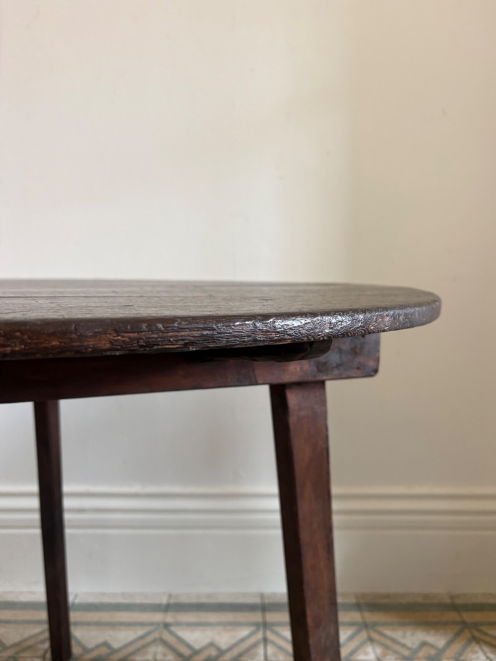 A nineteenth-century round wooden cricket table featuring a circular oak plank top resting on three dark pine legs. View II