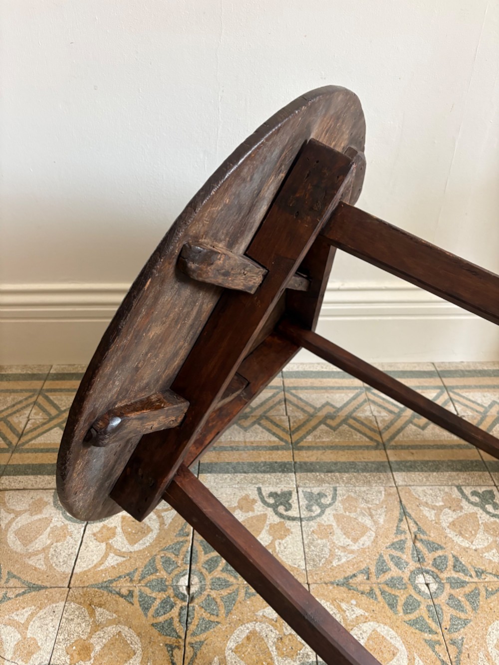 A nineteenth-century round wooden cricket table featuring a circular oak plank top resting on three dark pine legs. View VII