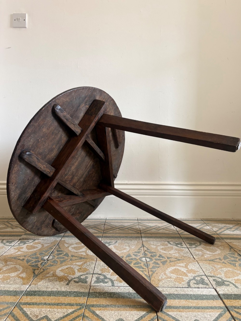 A nineteenth-century round wooden cricket table featuring a circular oak plank top resting on three dark pine legs. View VIII