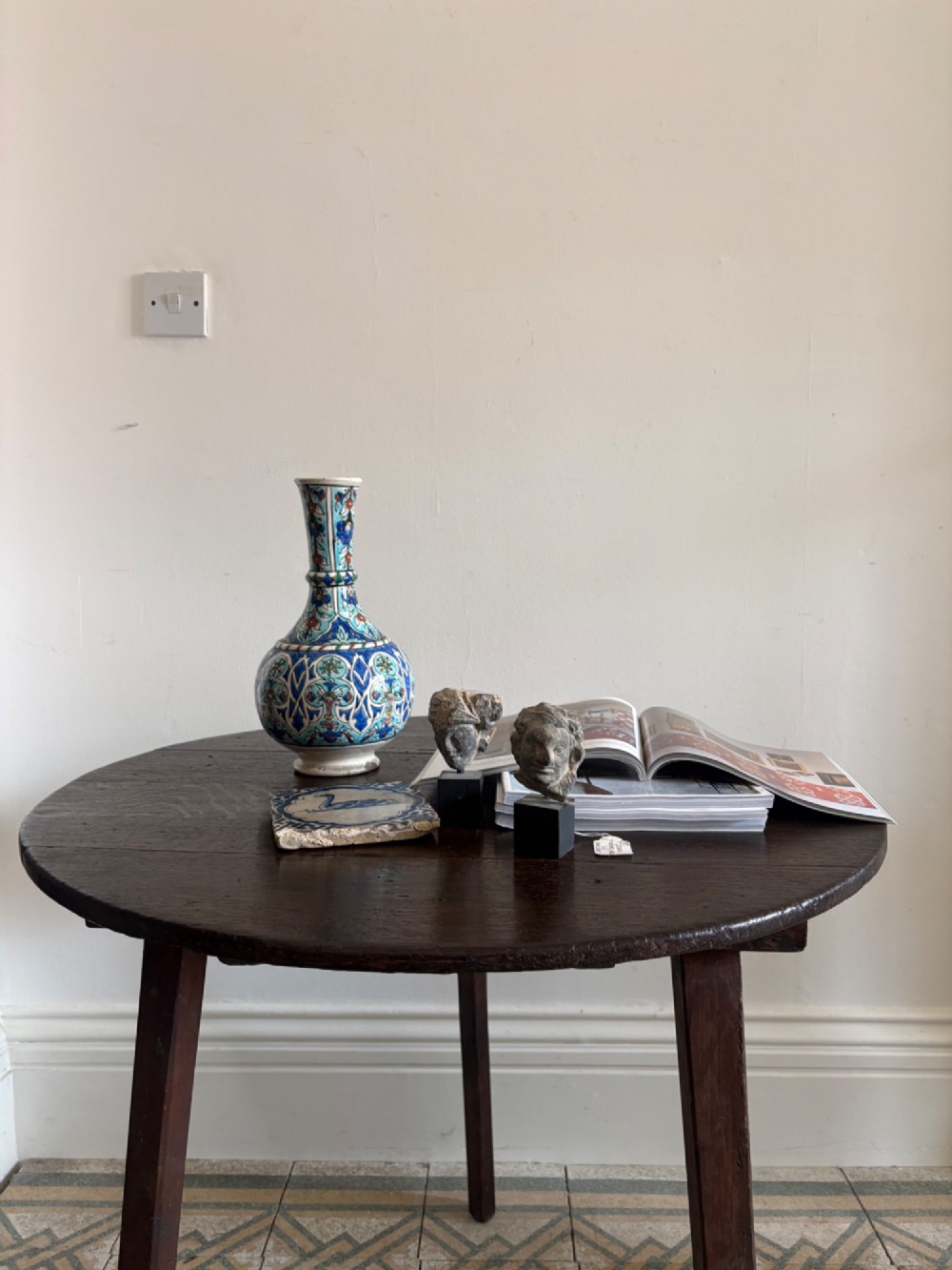 A nineteenth-century round wooden cricket table featuring a circular oak plank top resting on three dark pine legs. View IX
