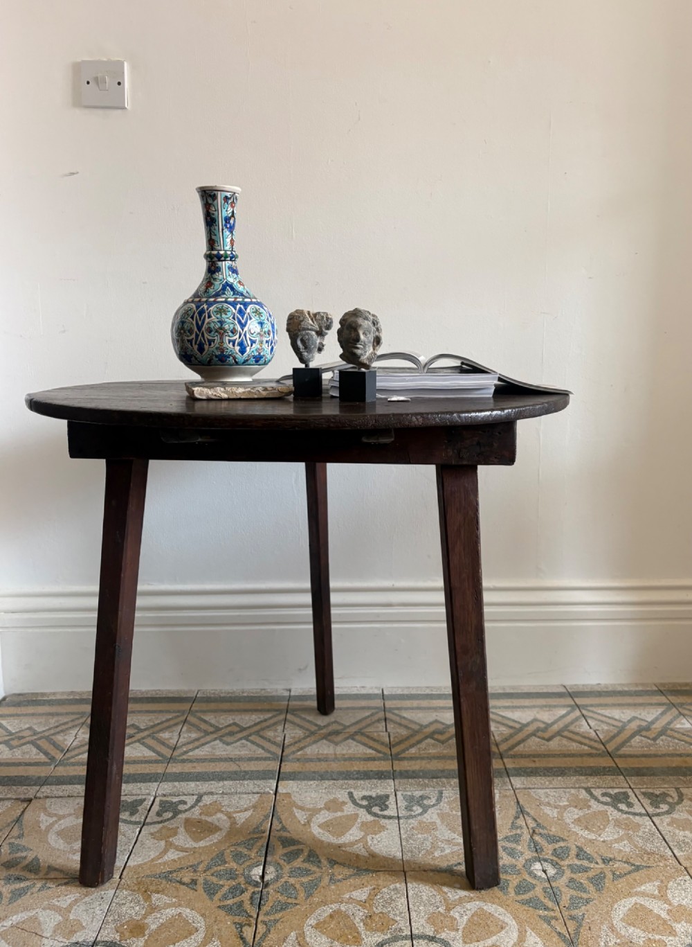 A nineteenth-century round wooden cricket table featuring a circular oak plank top resting on three dark pine legs. View X
