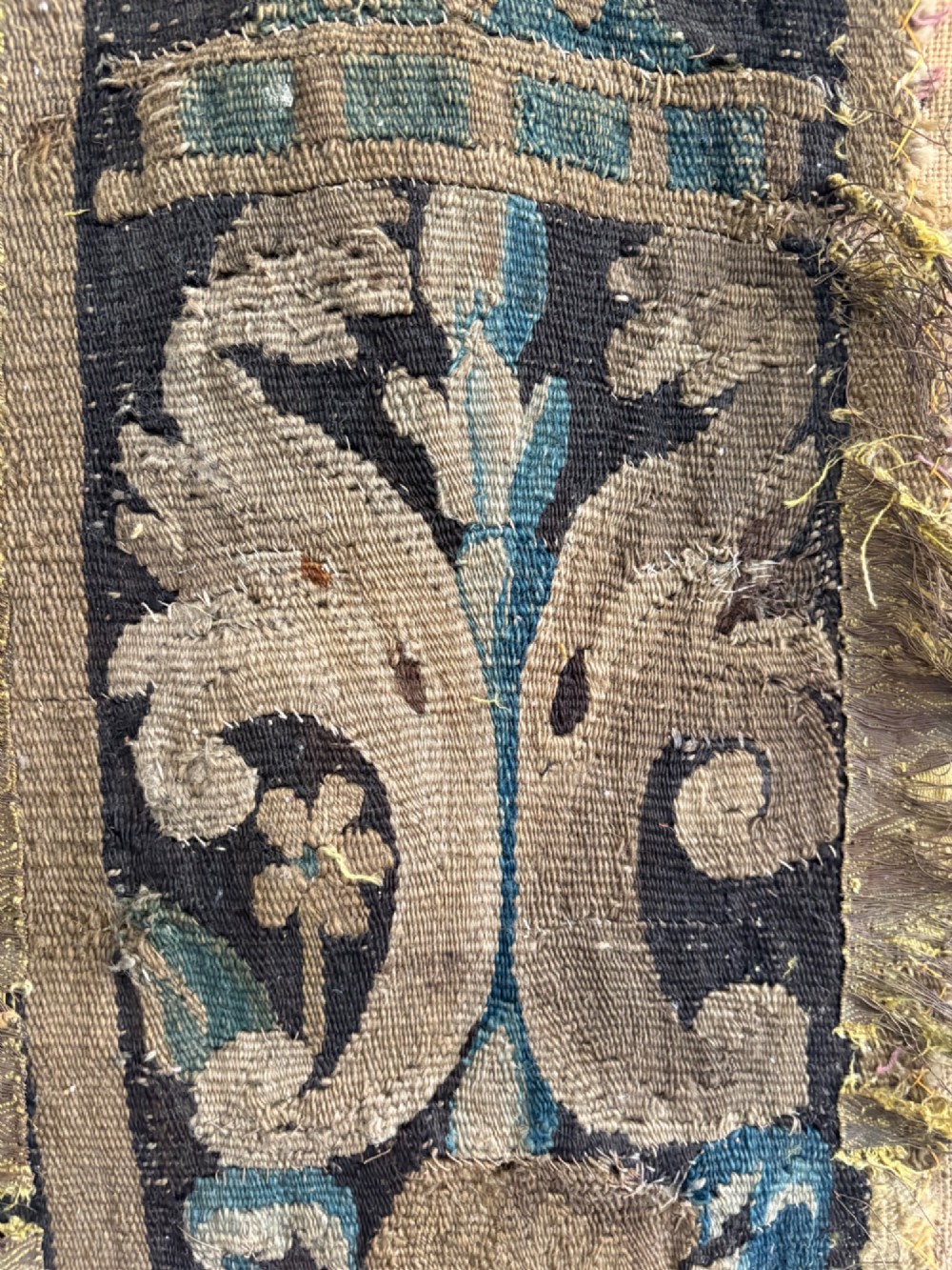 A vertical fragment of an antique hand-woven verdure tapestry featuring acanthus leaf motifs, mounted onto a natural linen backing. View III